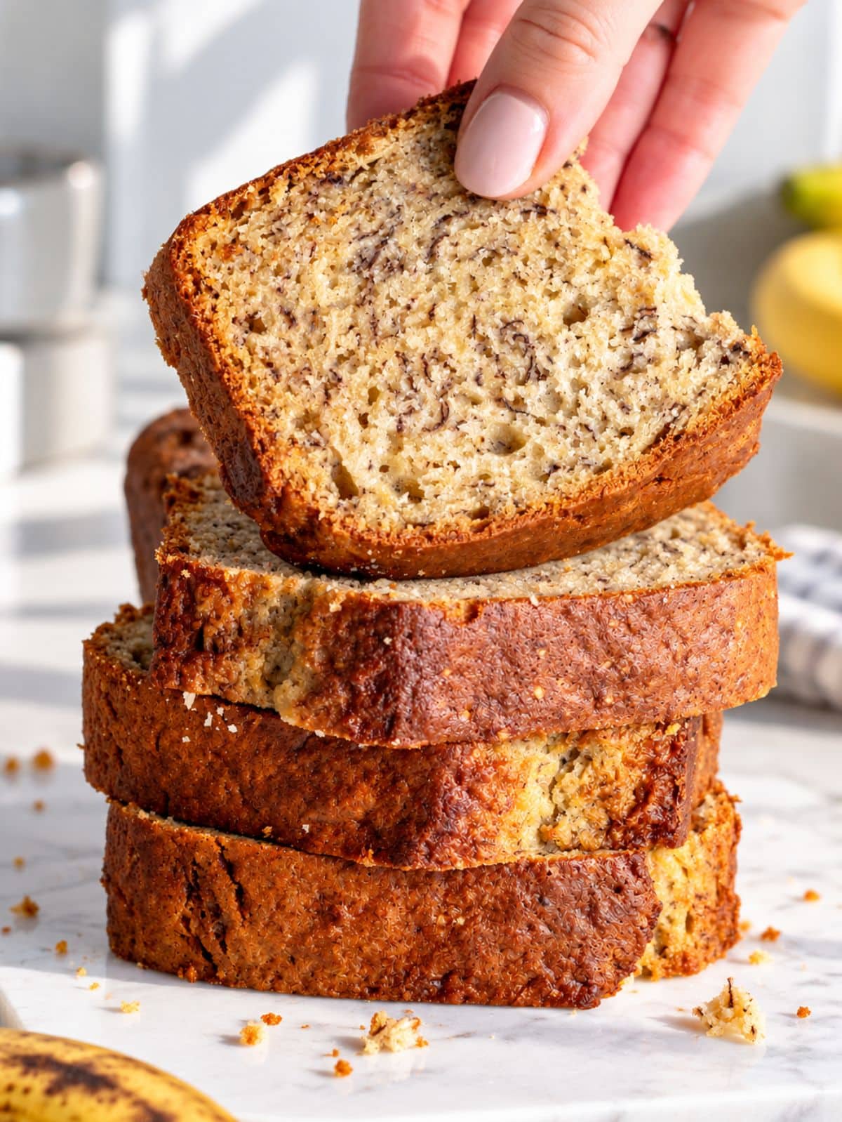 Sliced vegan banana bread with golden crust and soft, moist crumb.