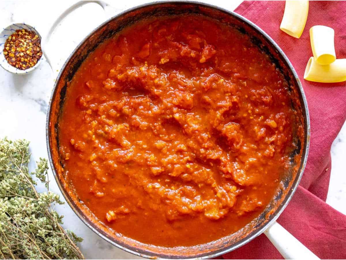 Step 2 Onion garlic and tomatoes simmering in pan for pasta alla Norma sauce.