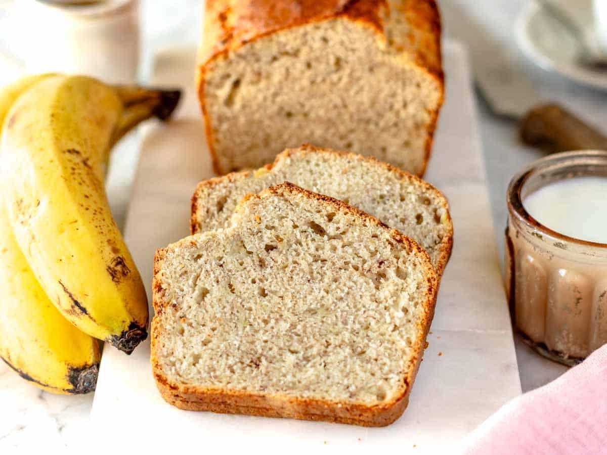 two slices of vegan banana bread on a marble cutting board