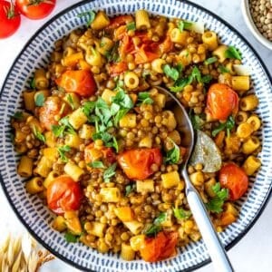 lentil pasta with cherry tomatoes and a blue spoon