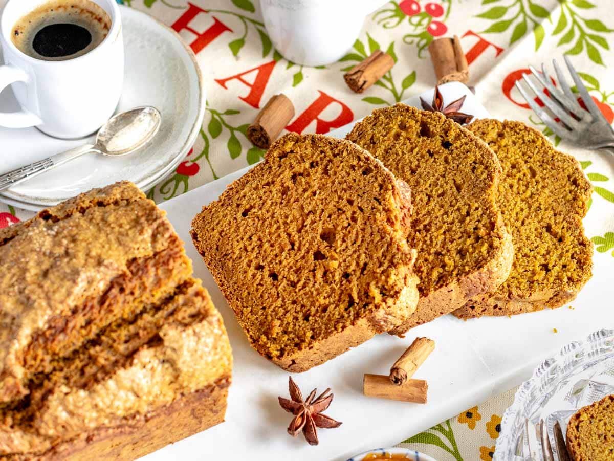 three slices of vegan pumpkin bread on an marble cutting board