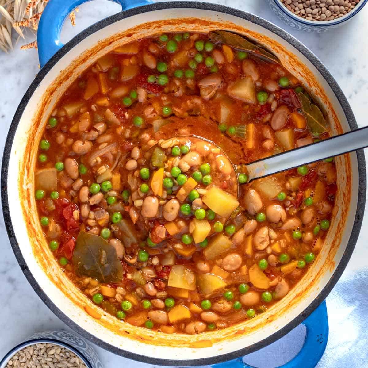 Barley soup with peas and beans in a blue pot