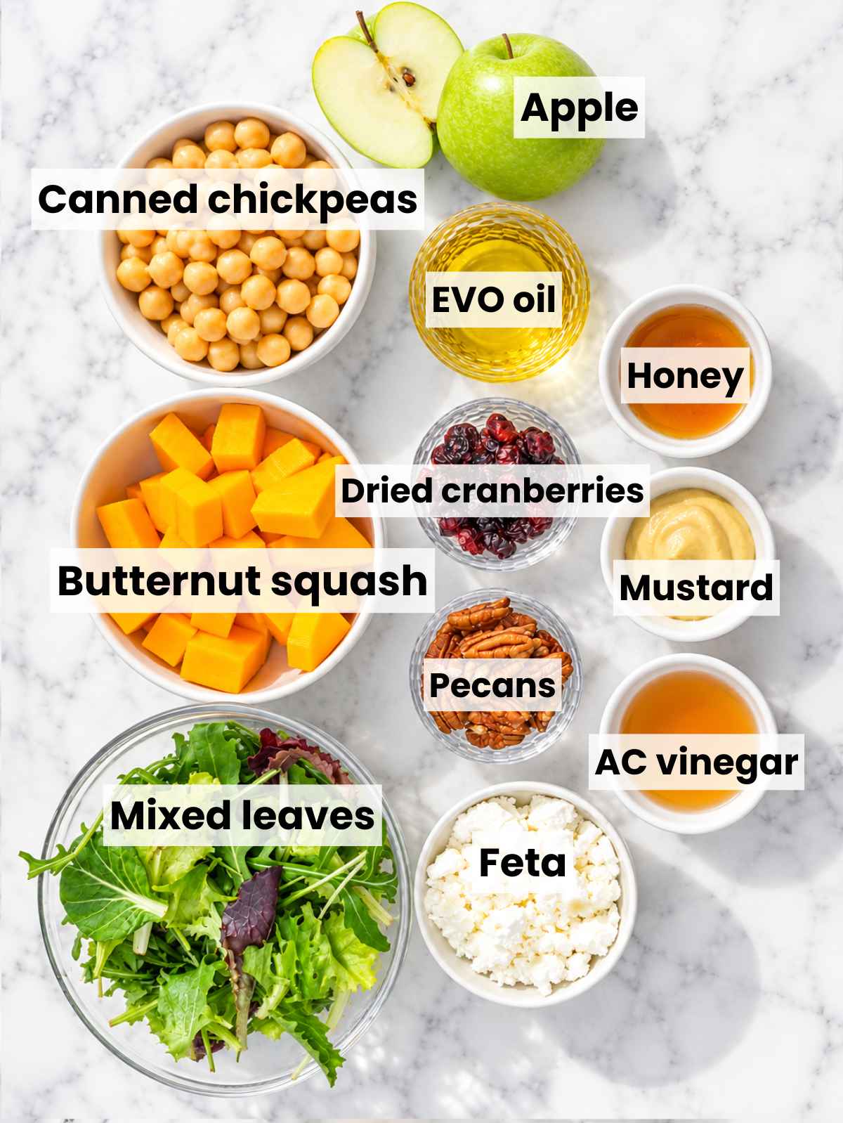 Butternut squash salad ingredients arranged on white marble in natural light