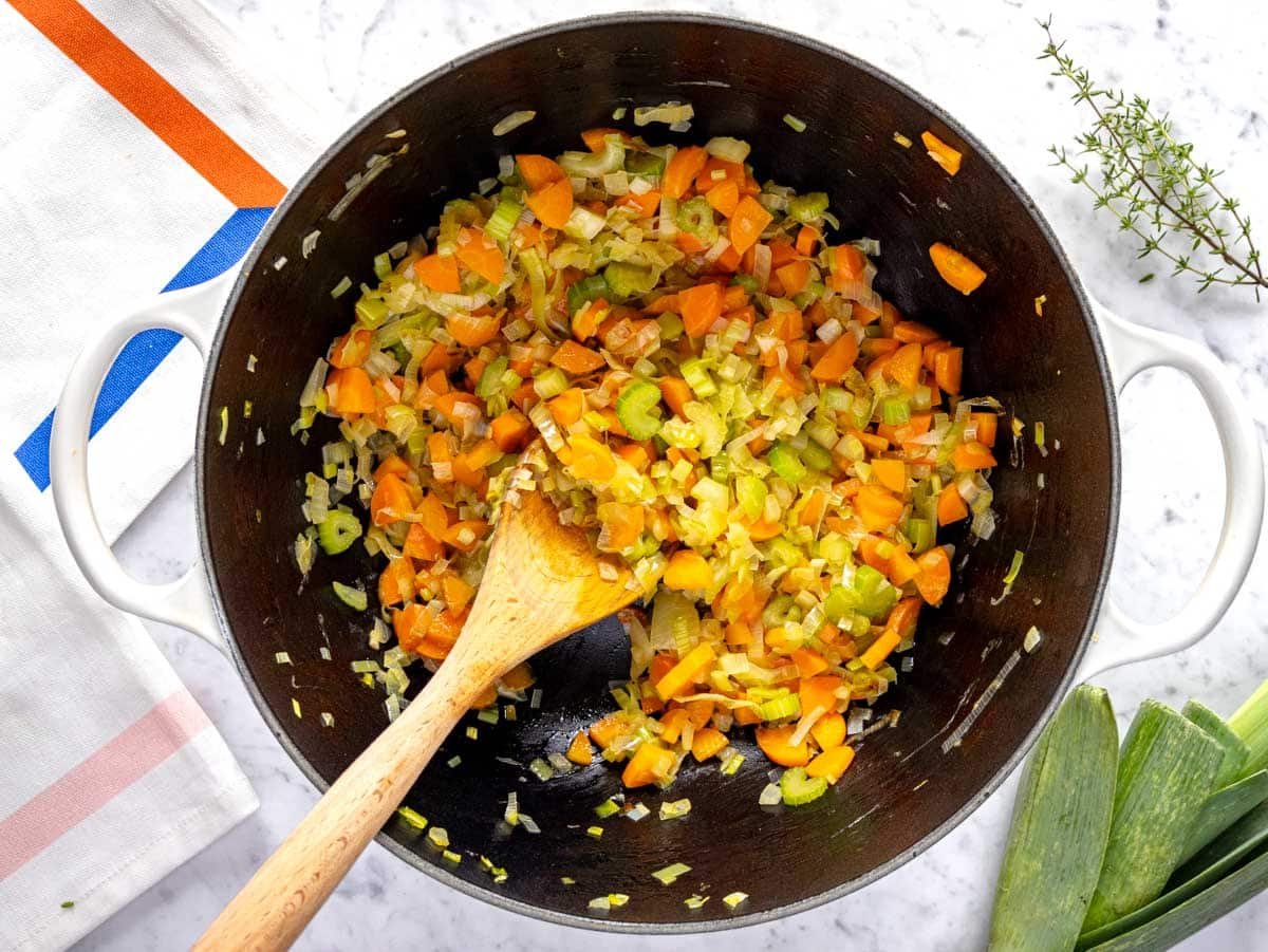 Flavor base with onion, carrot, leek and celery in a large pot