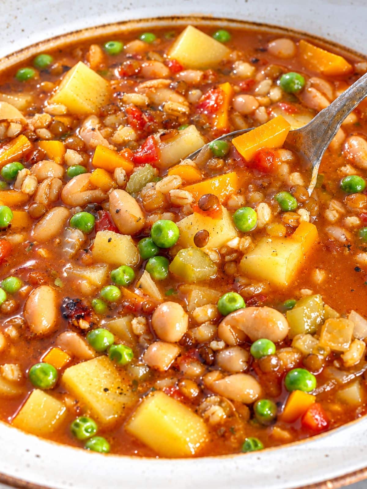 Close-up of glossy barley soup with kidney beans and creamy potatoes.