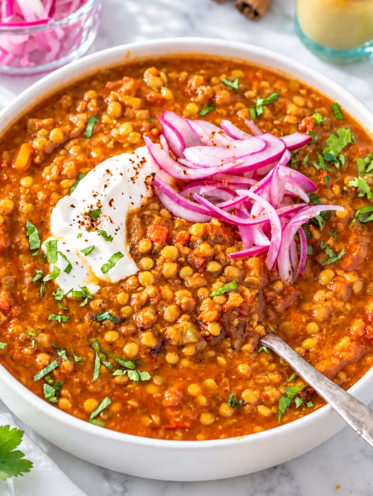 Close-up of tender lentils and diced vegetables in rich tomato broth.
