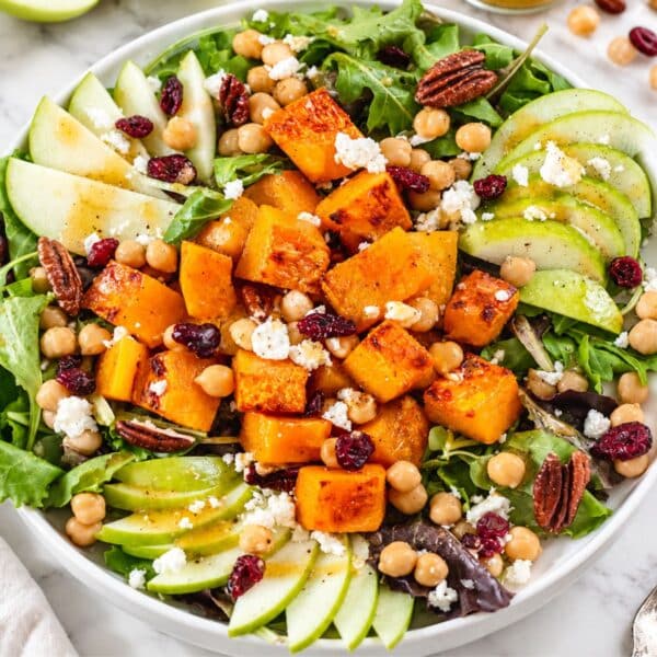 Colorful butternut squash salad with marinated chickpeas, apple, feta, and pecans.