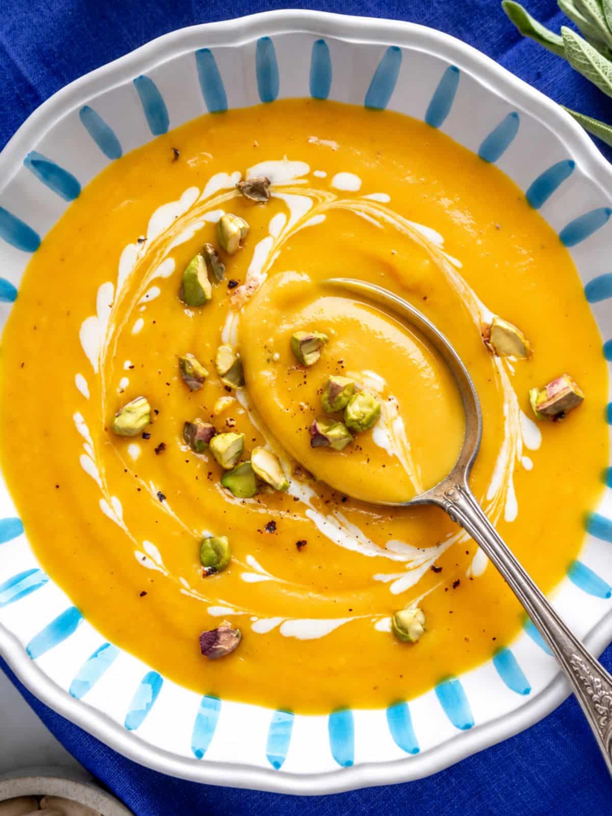 Creamy butternut squash soup topped with toasted nuts and cream.