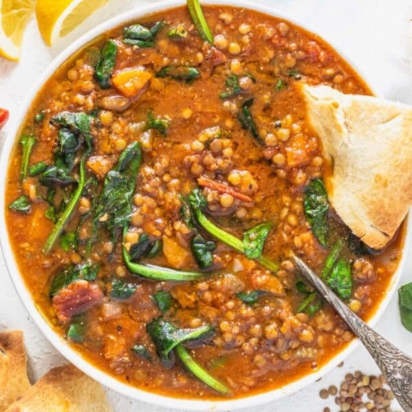 Lentil vegetable soup with spinach, a silver spoon and bread