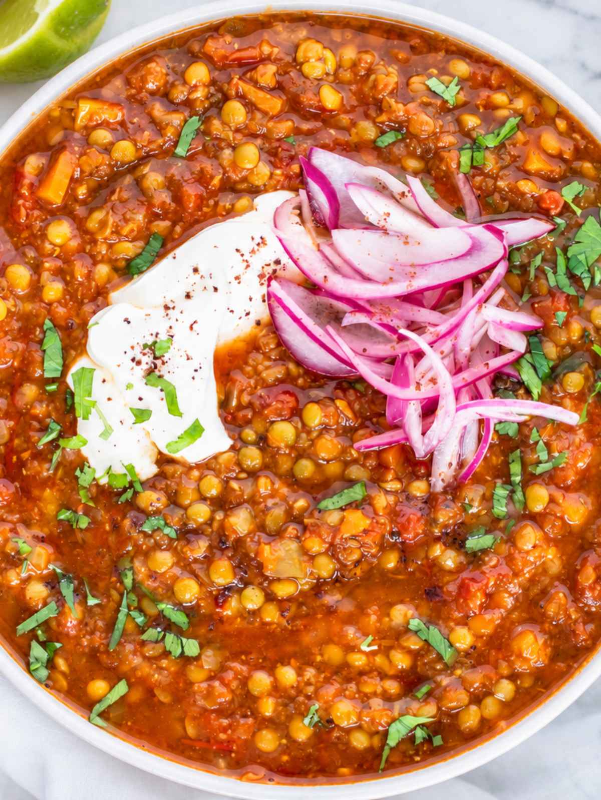 Moroccan lentil soup topped with fresh herbs and served with yogurt.