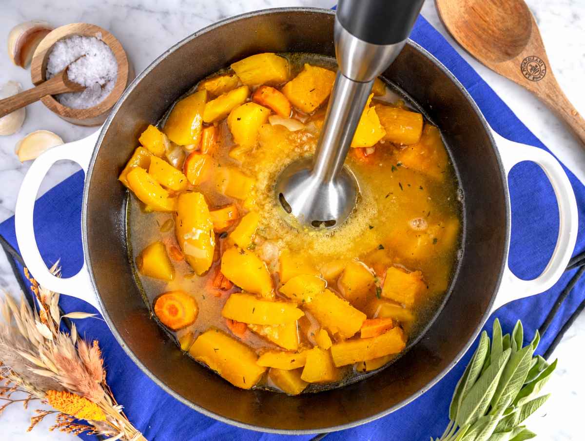 Step 2 An immersion blender blends roasted vegetables and broth into smooth soup.