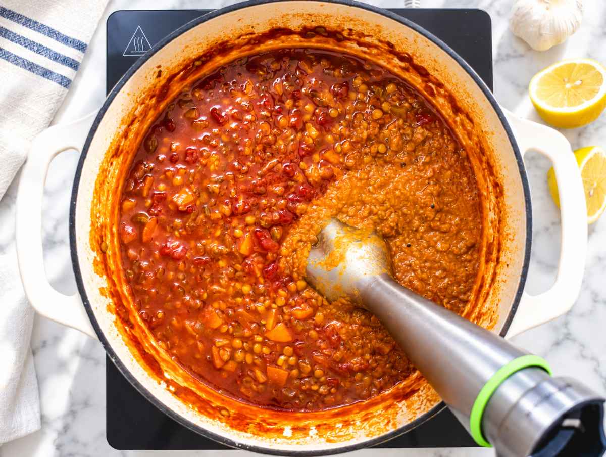 Step 3 Immersion blender partially blending the soup, leaving whole lentils and vegetables.
