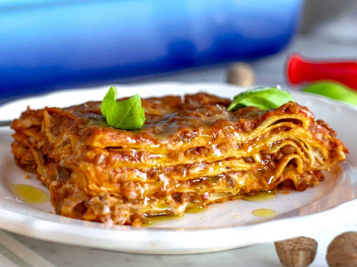 Creamy vegetarian lasagna dripping with white sauce and lentil bolognese.