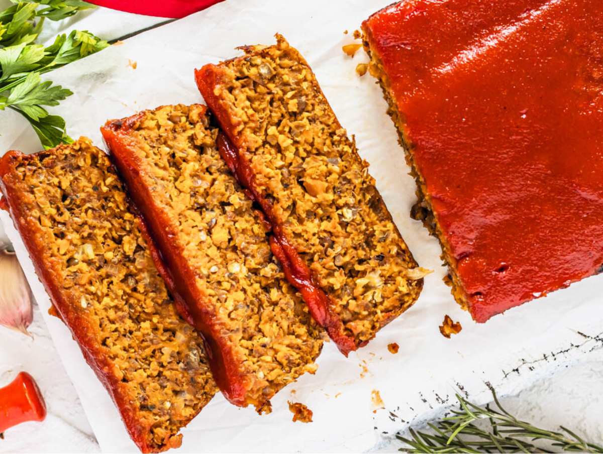 lentil loaf with three slices on a cutting board