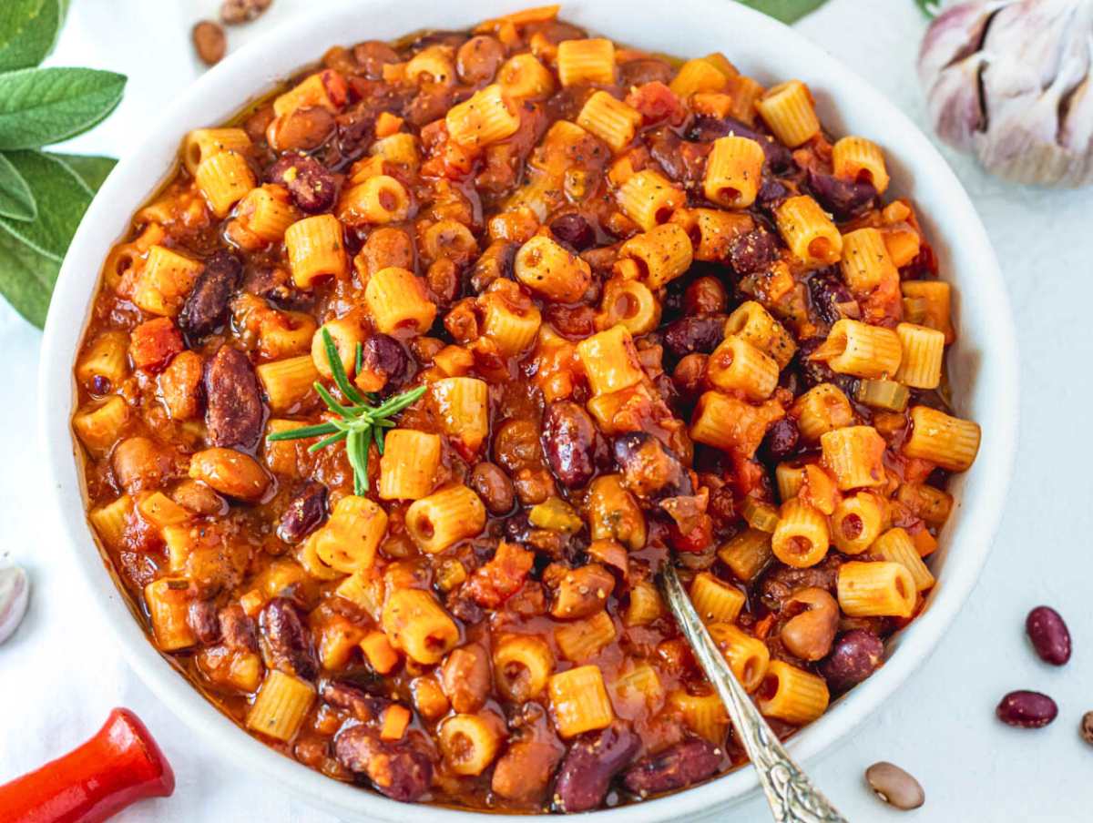 pasta and fagioli in a white bowl with a silver spoon