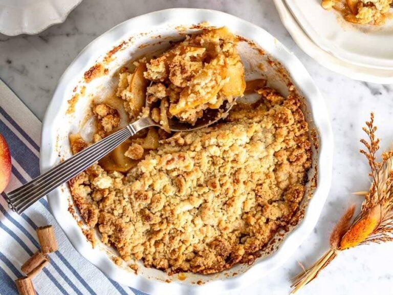 Apple crumble in pie dish and a cup of coffee