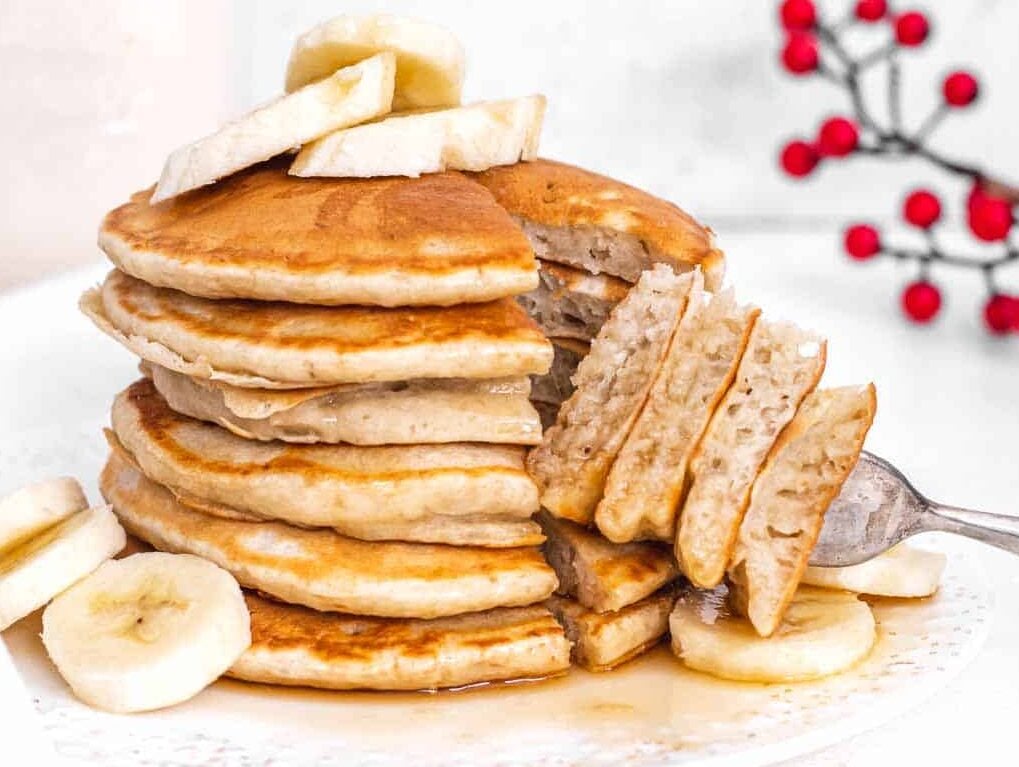 cut open banana pancakes with maple syrup