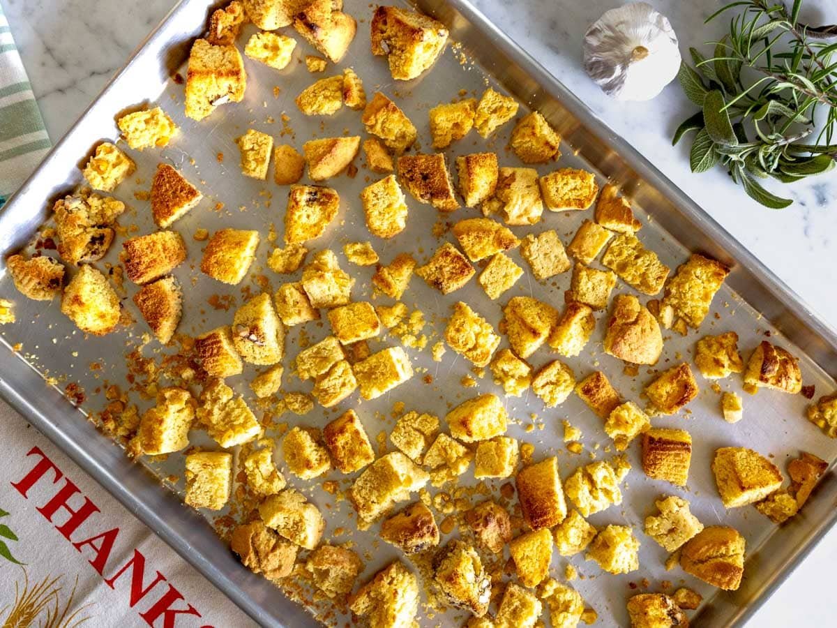 Roasted cubes of cornbread on a baking tray