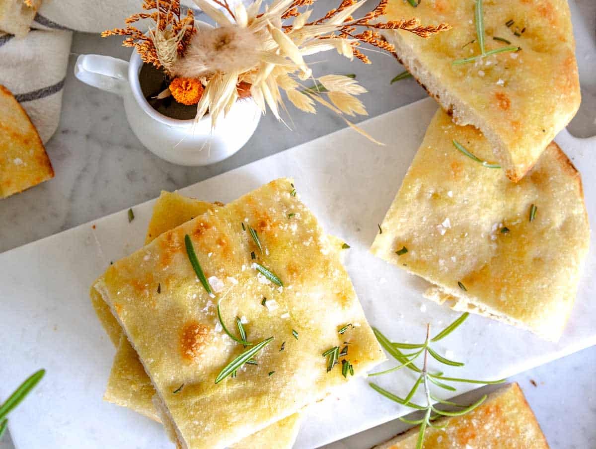 schiacciata cut into squares on a white cutting board.