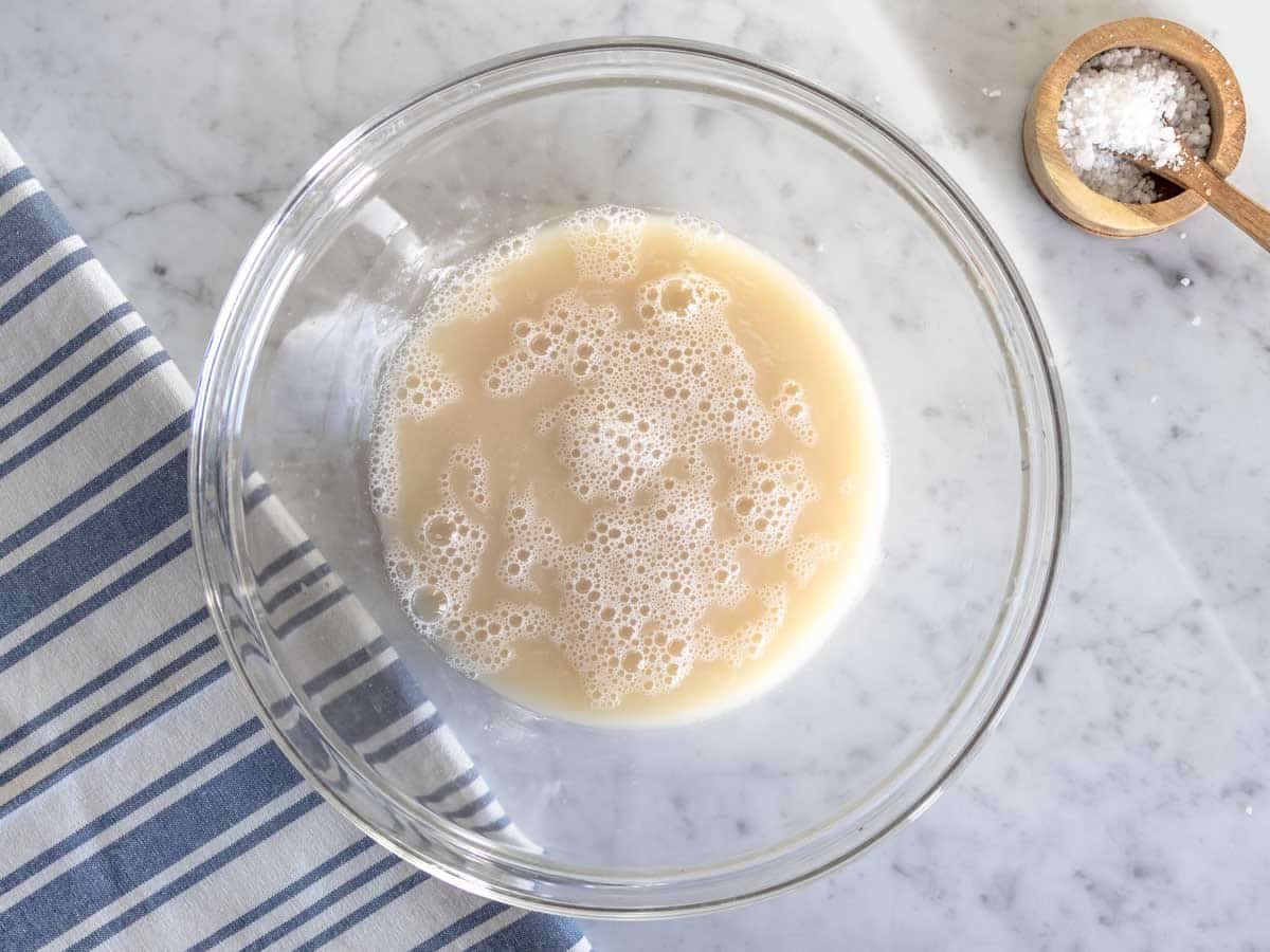 Dissolving yeast in a water in a large bowl.