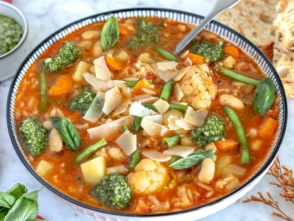 vegetable soup topped with pesto and parmesan