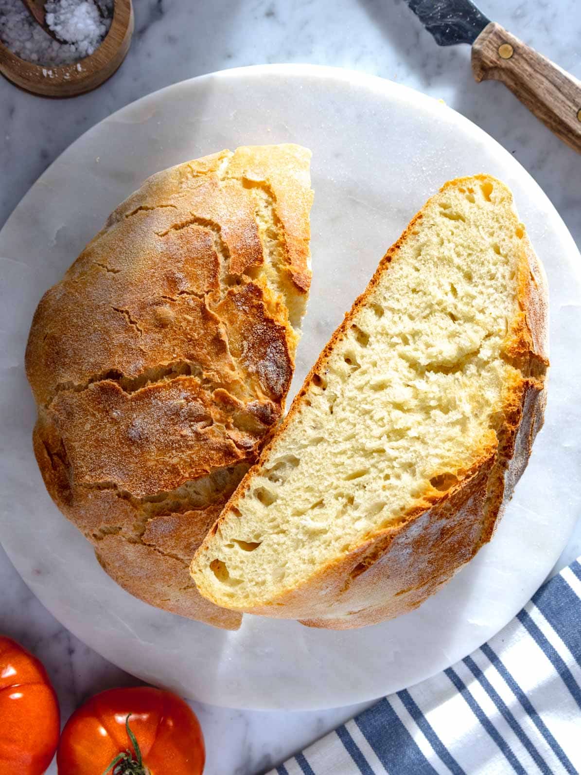 homemade artisan bread on a marble surface with a bread knife