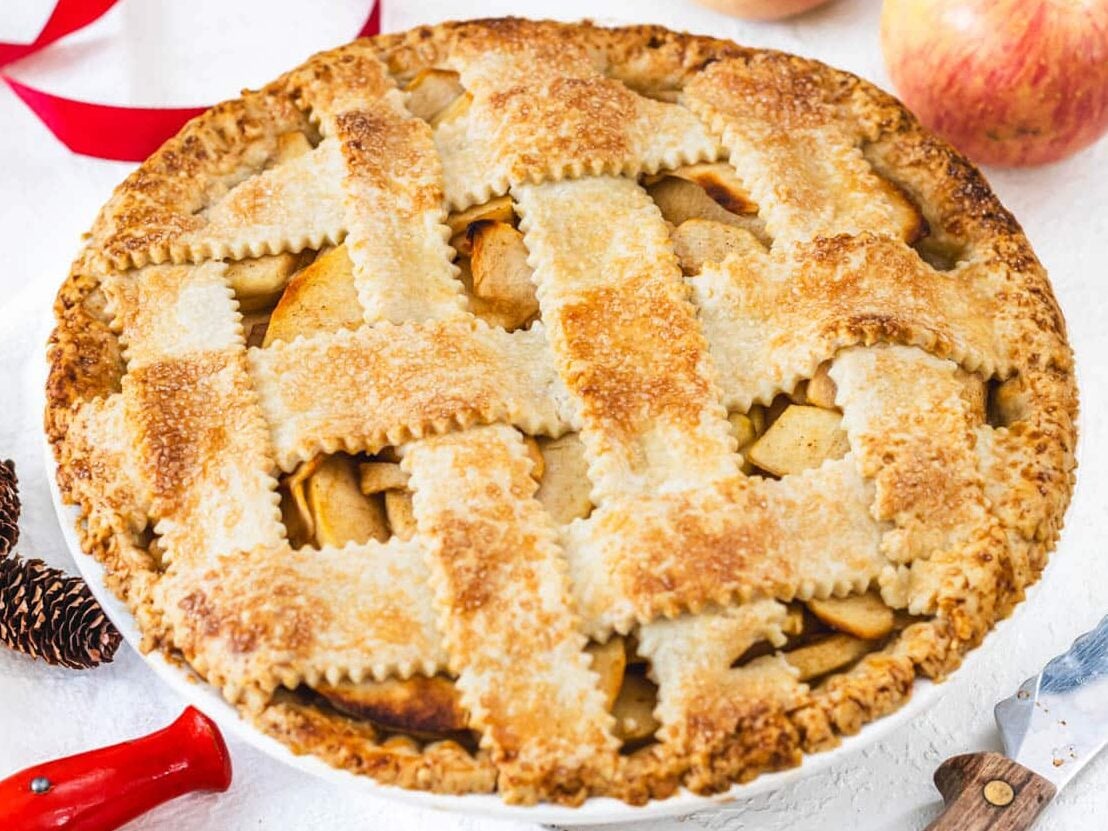 vegan apple pie with red apples and knife on the side