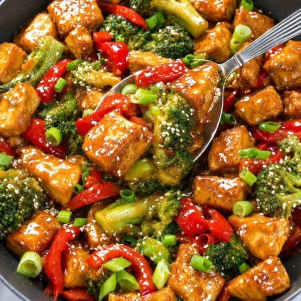 Orange tofu and broccoli over rice with glossy citrus sauce.
