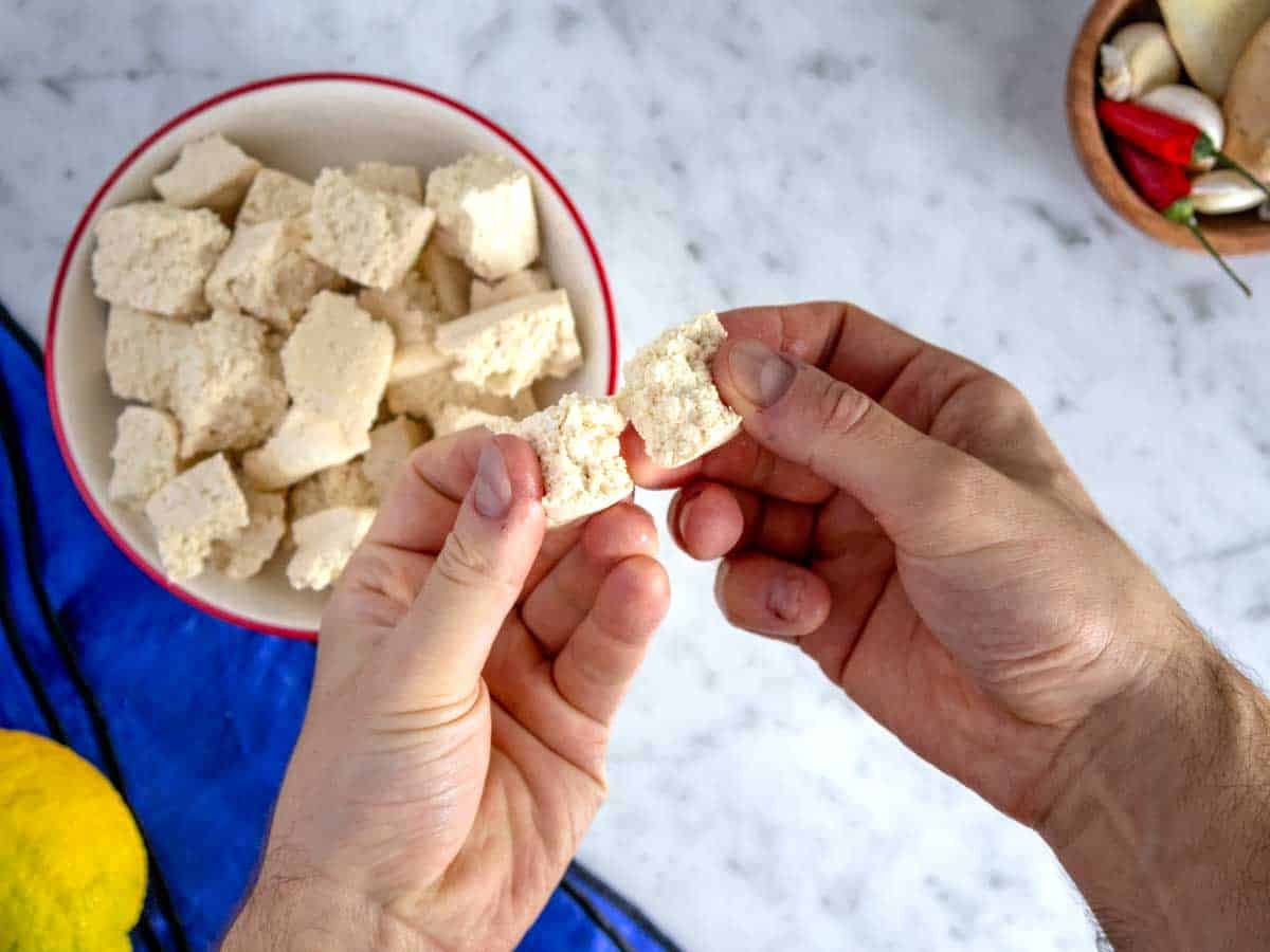 Pulling tofu apart into bite-size pieces.