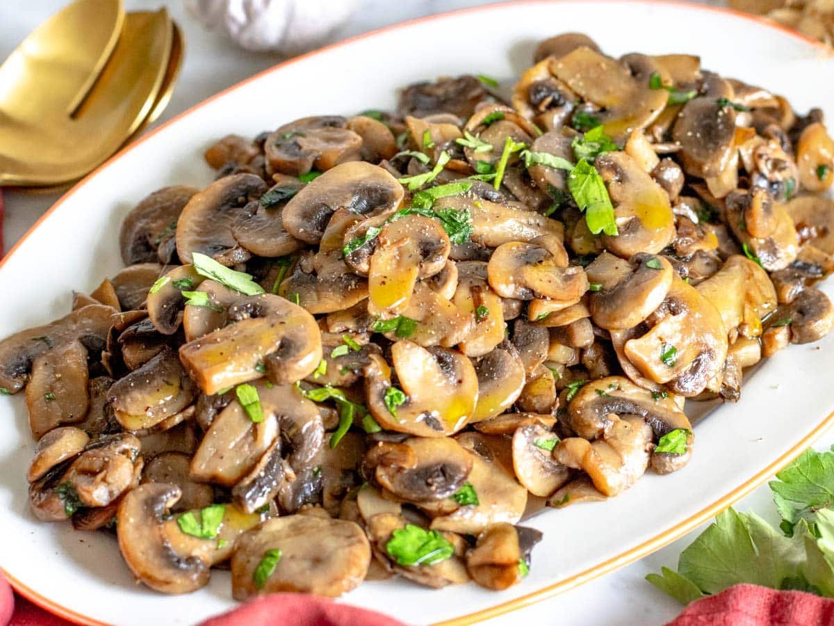 sauteed mushrooms with parsley served on a white platter