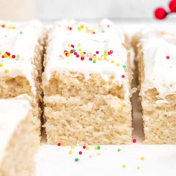 a slice of vegan vanilla cake with cream cheese frosting.