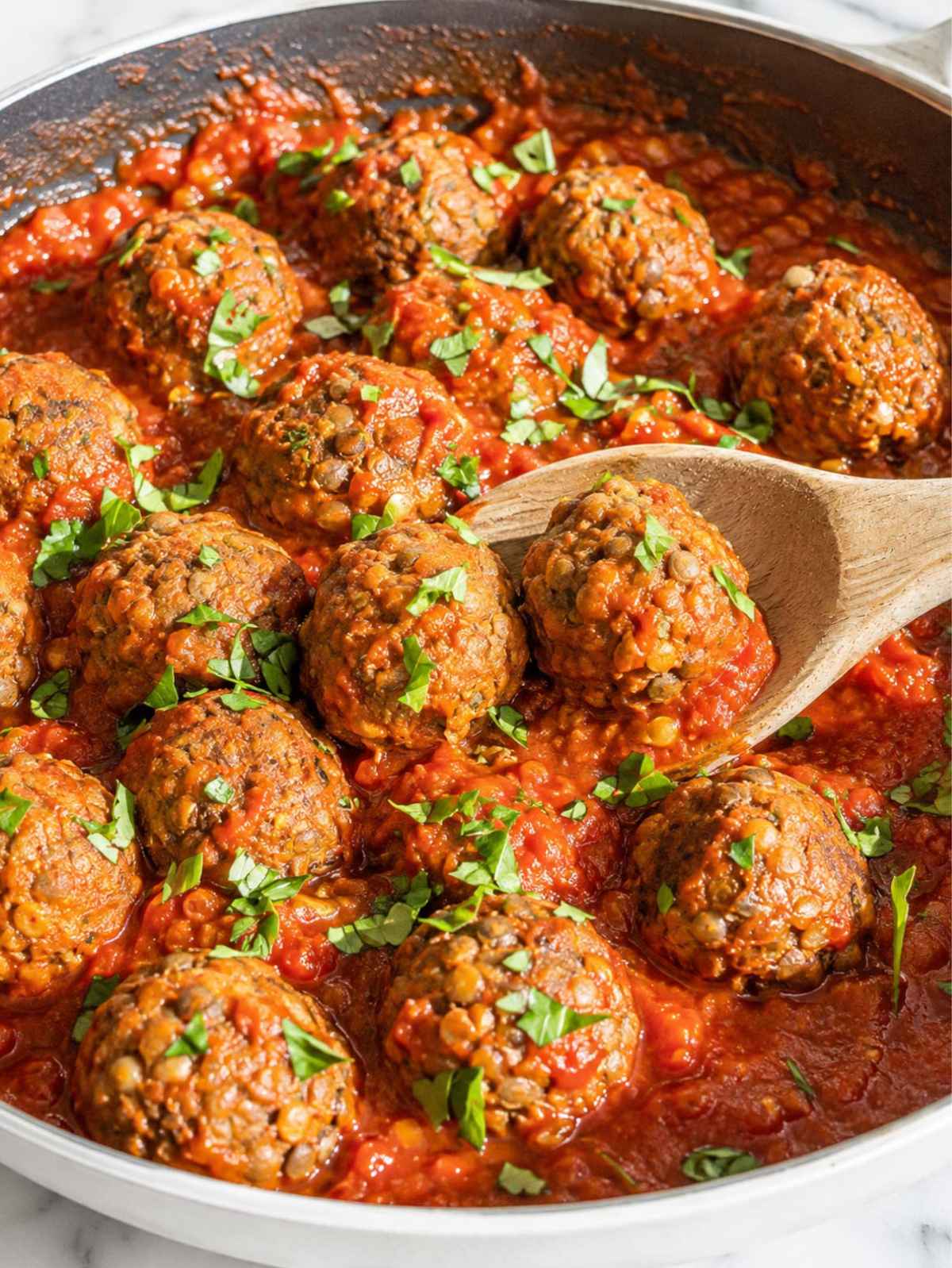 Golden lentil meatballs served with marinara sauce and fresh parsley.