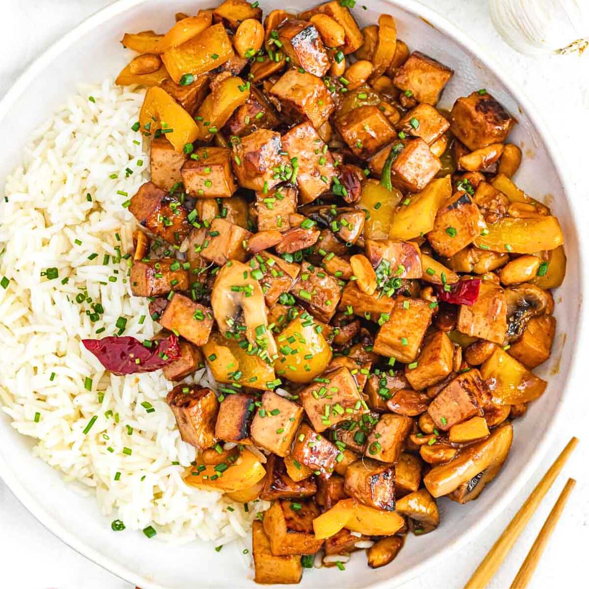 Kung pao tofu with rice in a white bowl.