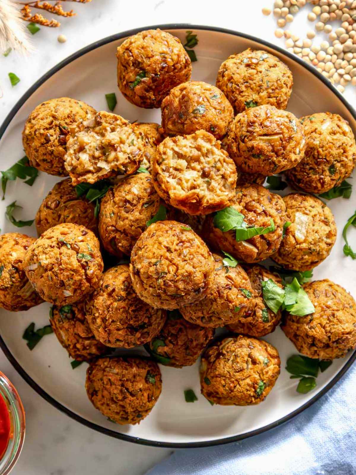 Lentil meatballs with fresh parsley served on a plate.