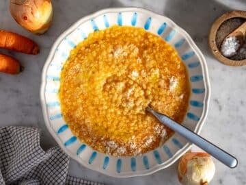 Pastina served in a bowl with grated parmesan cheese and olive oil.