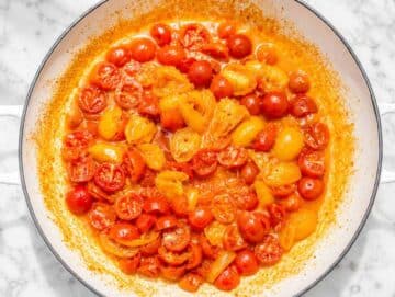 Step 2 Cherry tomatoes cooking with garlic, olive oil, and red pepper flakes.