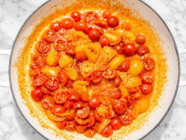 Step 2 Cherry tomatoes cooking with garlic, olive oil, and red pepper flakes.