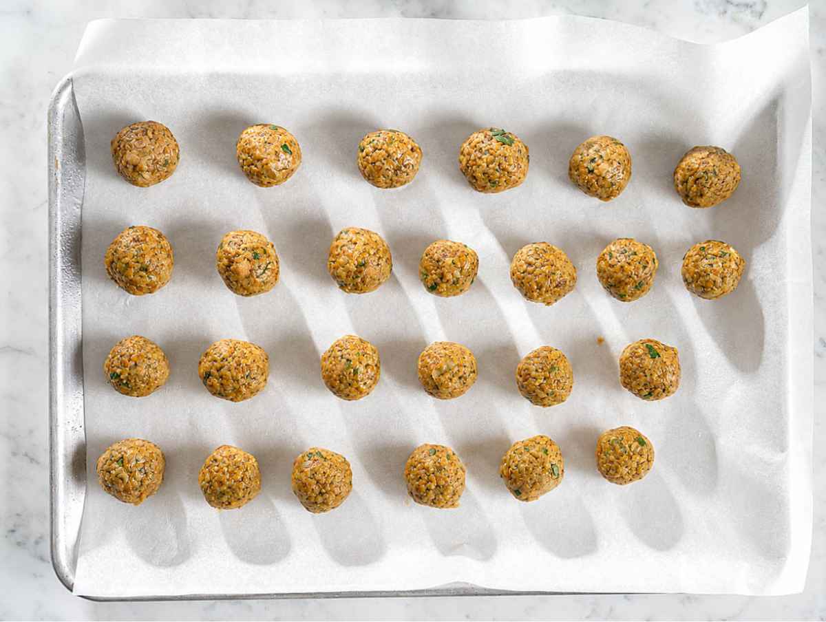 Step 2 Lentil mixture rolled into meatballs on a parchment-lined baking sheet.