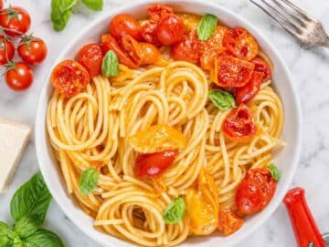 Step 4 Parmesan stirred into cherry tomato pasta until creamy and glossy.