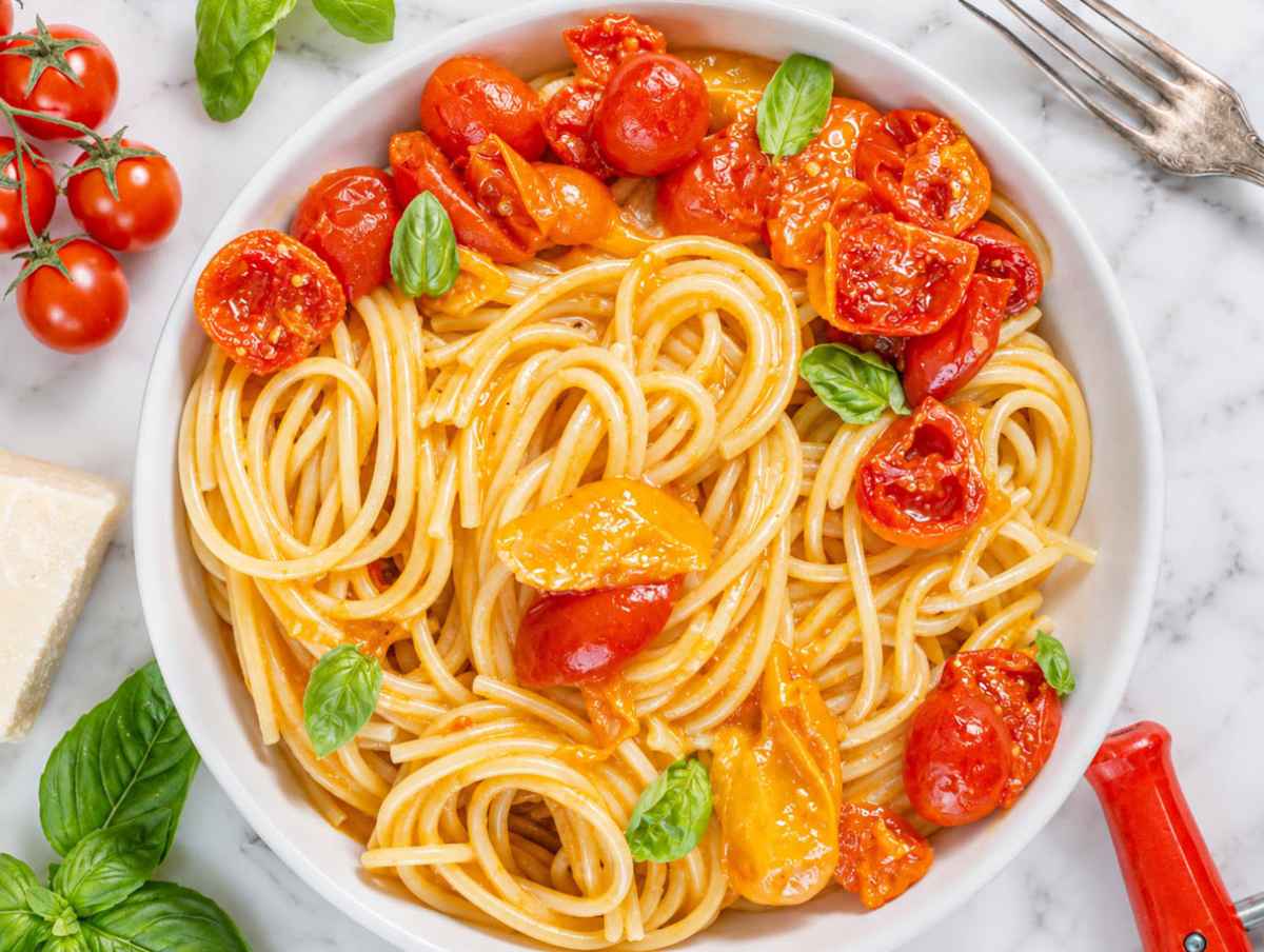 Step 4 Parmesan stirred into cherry tomato pasta until creamy and glossy.