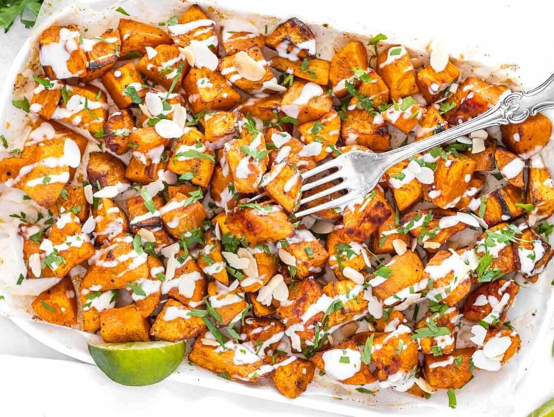 roasted sweet potato cubes drizzled with tahini sauce and parsley