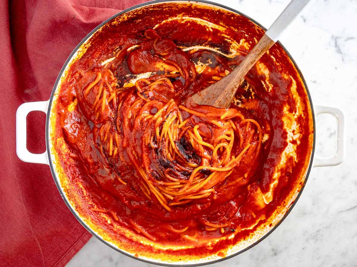 Charred spaghetti in assassin's sauce with a spatula.