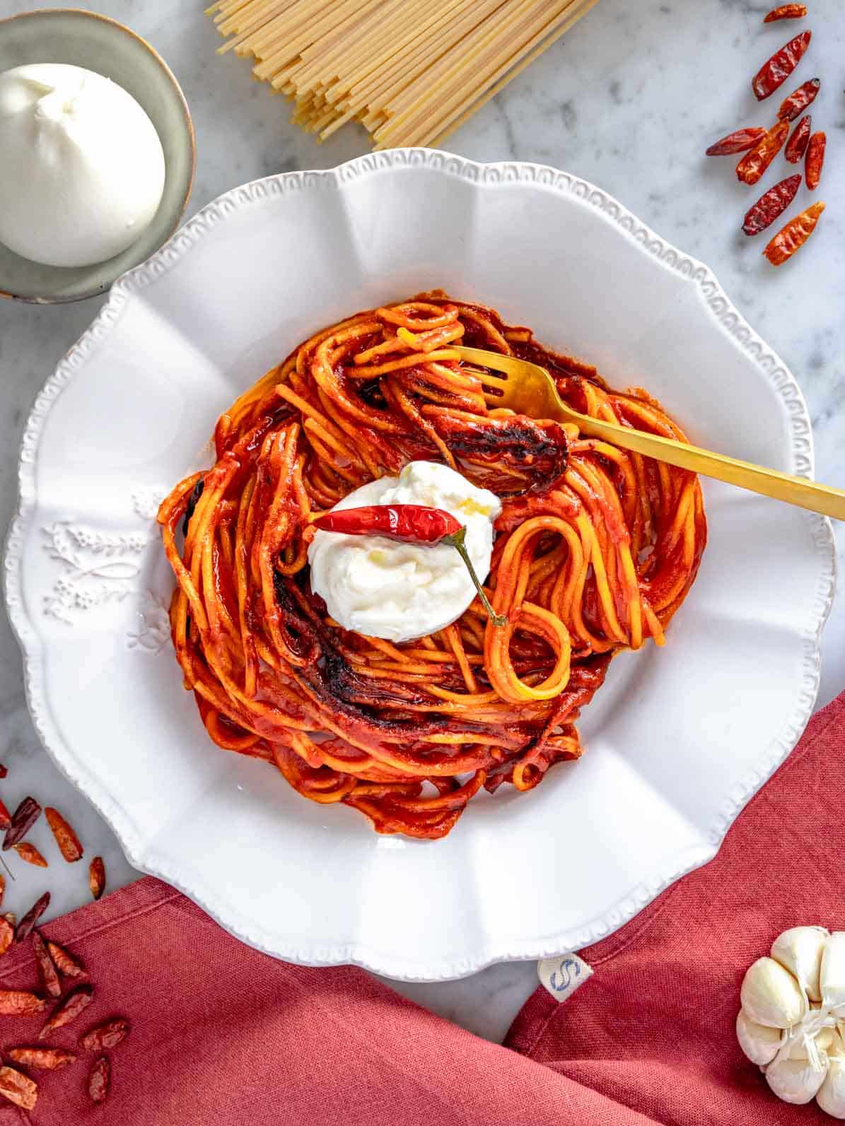 Assassin's pasta served in a white bowl with a golden fork.