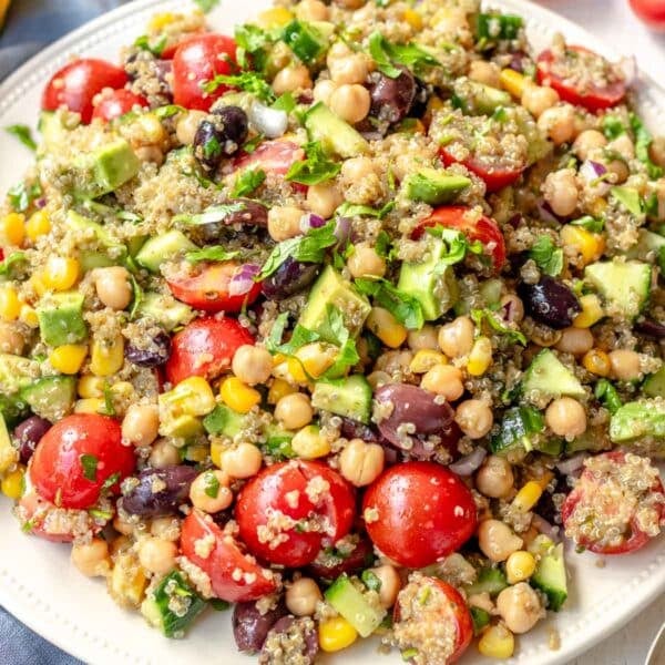 A vegan high protein meal with chickpeas, quinoa, and vegetables on a plate.