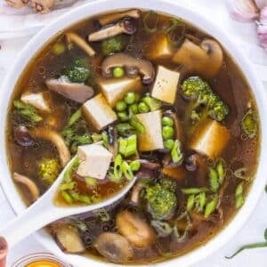 Easy one pot tofu soup with miso broth and fresh toppings on table.