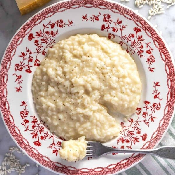 Creamy parmesan risotto on a red plate.