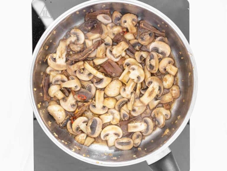 Step 1 Garlic ginger chili and mushrooms sautéing in pot for flavorful tofu soup base.