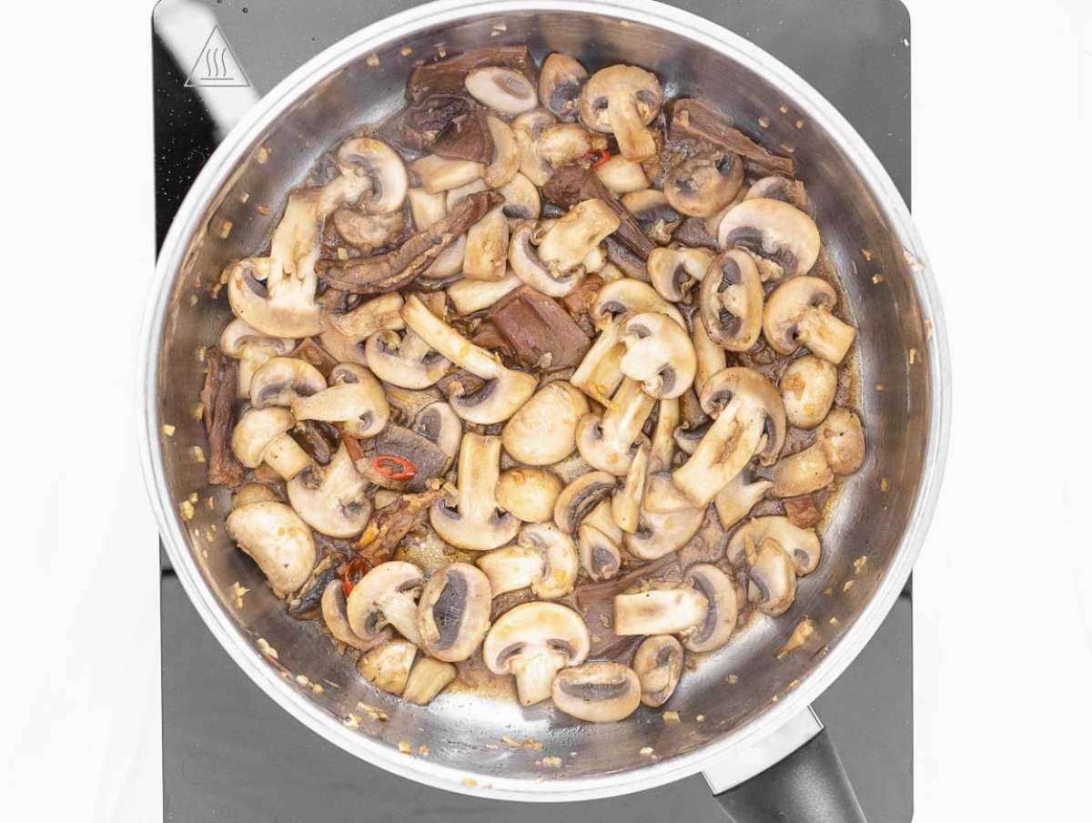Step 1 Garlic ginger chili and mushrooms sautéing in pot for flavorful tofu soup base.