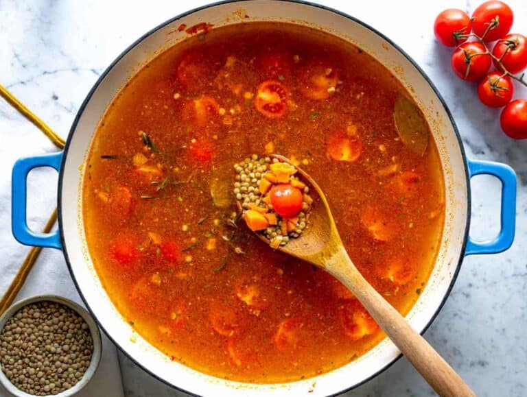 Step 2 Lentils and cherry tomatoes simmering with herbs in savory vegetable broth.