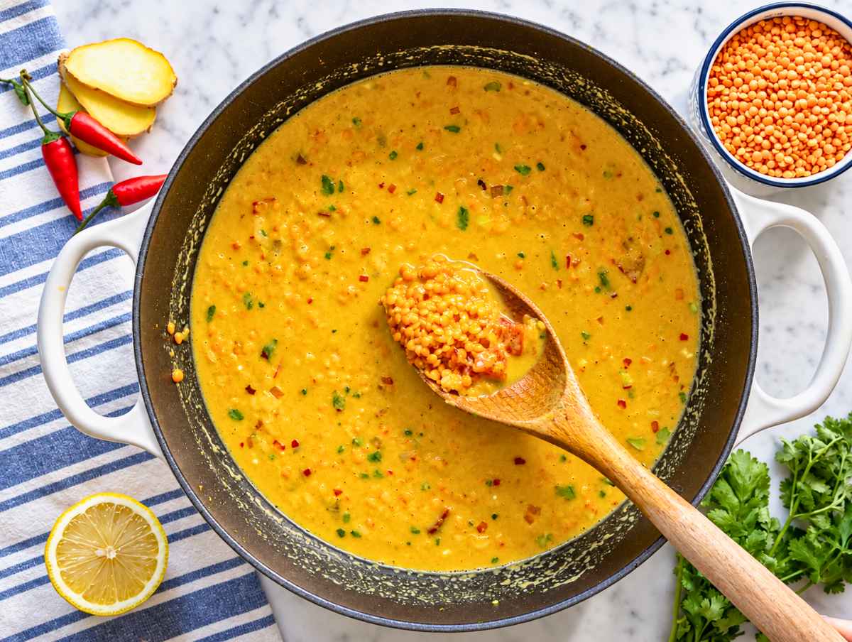 Step 2 Red lentils stirred with coconut milk, crushed tomatoes, and vegetable broth in the pot.